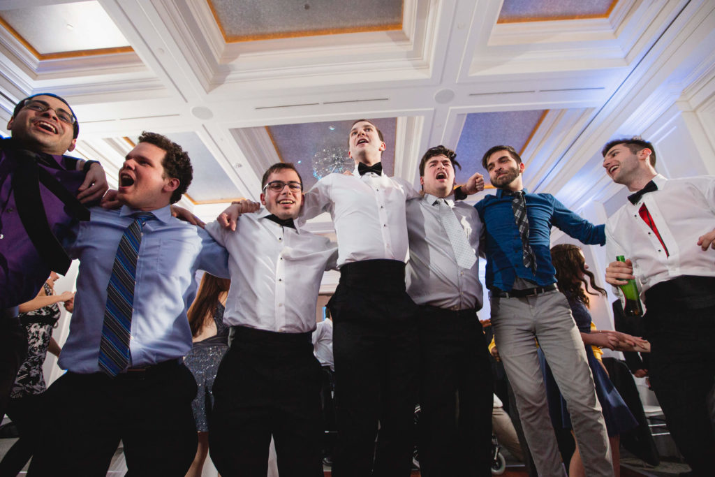 Photojournalistic wedding photography wedding reception groom with friends