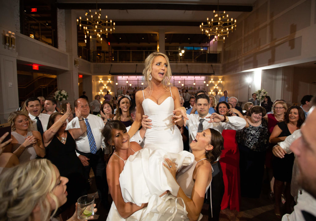 Photojournalistic wedding photography wedding reception bride lifted in chair