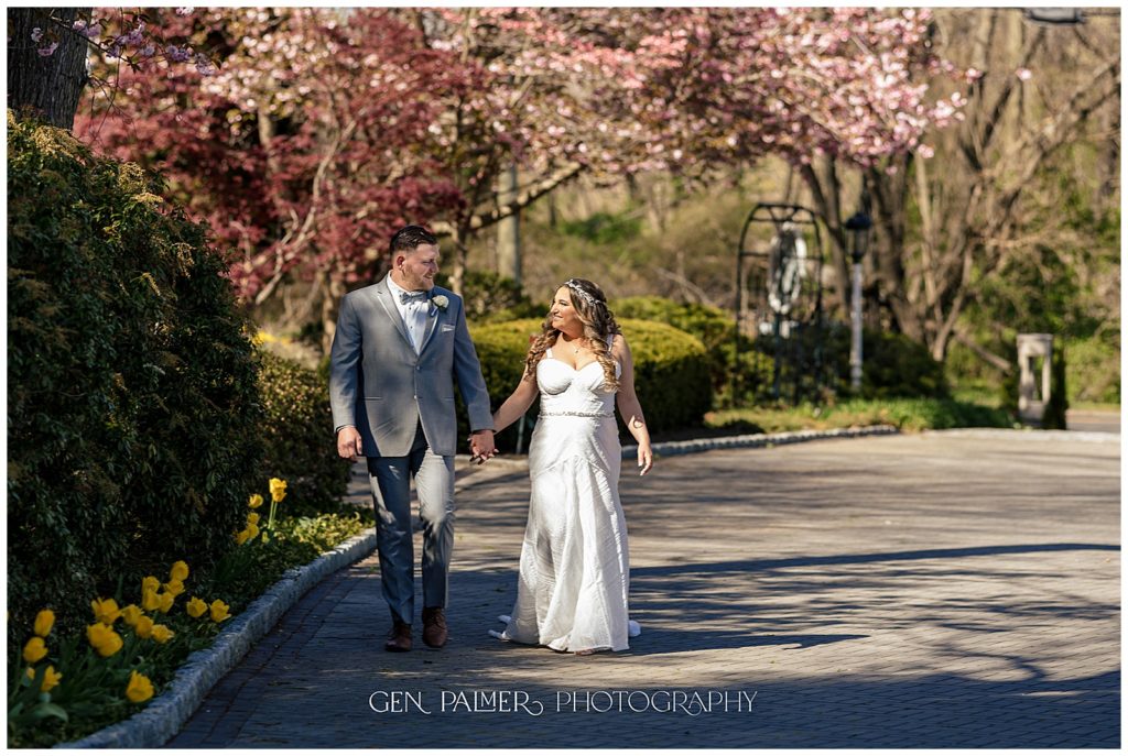 Spring Estate at Eagle Lake Wedding Bride and Groom Walking with Cherry Blossoms