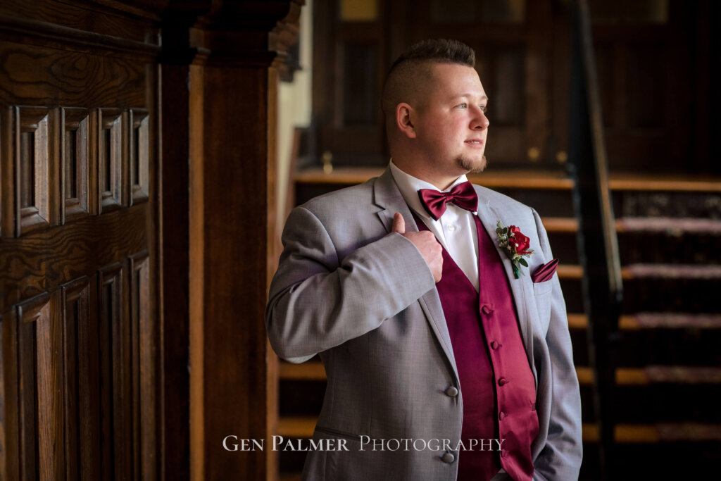 Groom flexing his red vest with gray coat at Collingswood Grand Ballroom