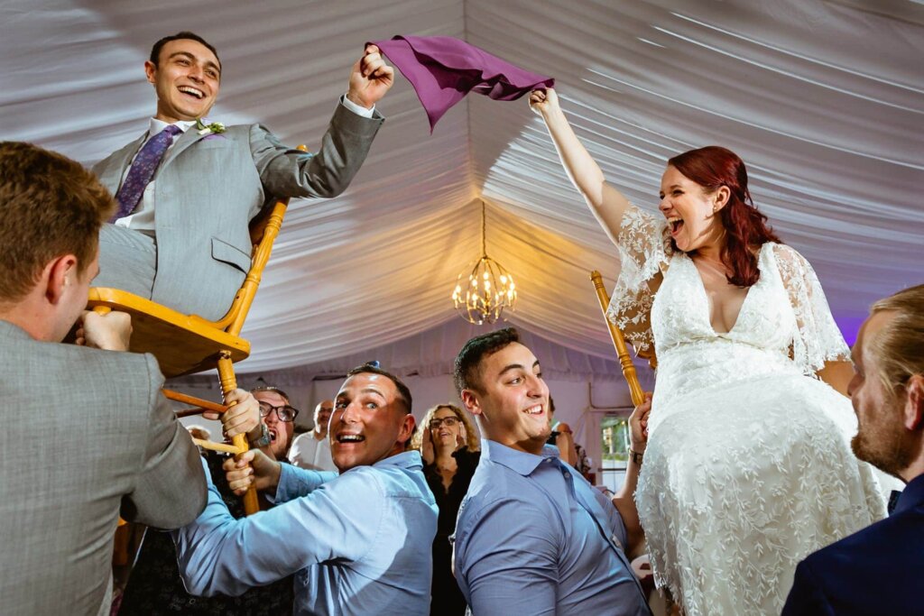How to Choose a Wedding Photographer | Couple having fun dancing the horah at their wedding reception