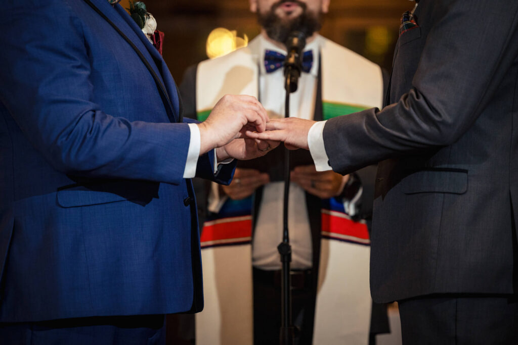 Groom putting ring on groom at Aldie Mansion